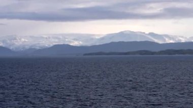 Norveç 'in güzel doğa manzarası, Norveç' teki pitoresk fiyort boyunca yolculuk, gemiden manzara, Norveç 'in kuzeyinde Senja kıyısı, bir teknenin arkasından manzara. Kuzey Norveç 'te Senja' nın kıyıları bir teknenin arkasından görülüyor..