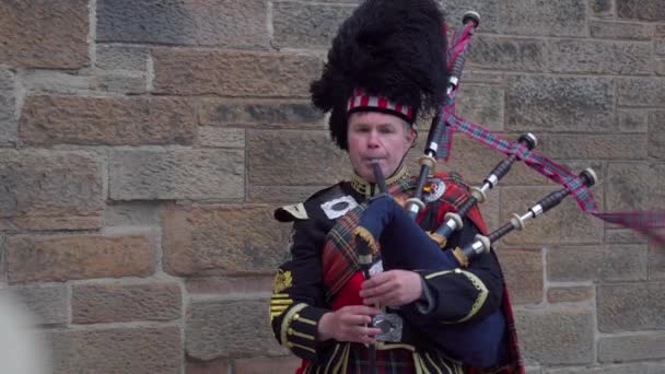 一个穿着苏格兰短裙的男人在吹奏风笛 一个穿着格子衣服的男人在苏格兰的音乐会上 音乐家身穿传统的格子呢短裙 吹奏苏格兰的风笛 人吹奏乐器风笛 吹奏苏格兰的风琴 — 图库视频影像