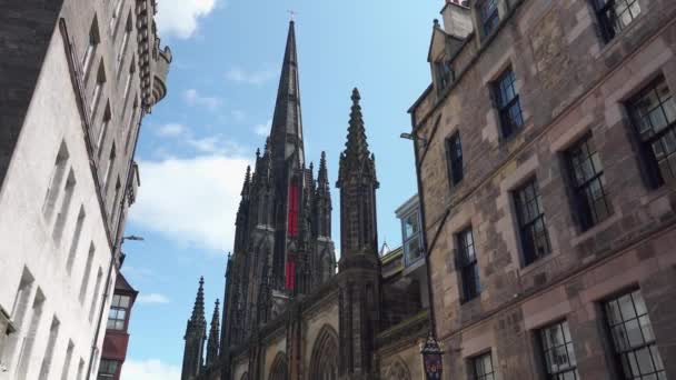 古い教会スコットランド エジンバラ近代的な建物と混合古い建築物 城内では 古代の建物とその隣に輝く近代的な建物のコントラストに気づくでしょう 旧市街 エジンバラ時計と有名な古い教会 — ストック動画