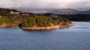Norveç 'in güzel doğa manzarası, Norveç' teki pitoresk fiyort boyunca yolculuk, gemiden manzara, Norveç 'in kuzeyinde Senja kıyısı, bir teknenin arkasından manzara. Kuzey Norveç 'te Senja' nın kıyıları bir teknenin arkasından görülüyor..
