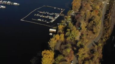 Yatlar, sürat tekneleri ve tekneler için park yeri olan güzel büyük bir koy. Yaz. Yatın sinematik hava görüntüsü, güzel körfezde iskeleye park etmiş birçok yelkenlinin havadan dikey görüntüsü, tekne ve yat manzarası, yat parkı.