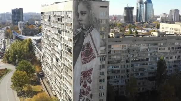 刺繍シャツの女性 キエフ ウクライナ 描かれたと 地下落書き キエフ ウクライナだ 夏の日キエフの美しい落書きストリートアートの空中ビュー カメラは刺繍シャツの女性と古い建物から立ち上がります — ストック動画