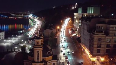 Gece şehri Kiev. Ukrayna. Dinyeper nehri üzerindeki köprü. Gece Kenti Kyiv. Ukrayna. Dnipro nehri üzerindeki köprü. Yaya köprüsü. Kiev 'in merkezinde modern bir bölge. Şehir ışıkları. Avrupa Şehri 'nin Gece Havadan Görünümü Arabalardan Aydınlanmış Işıkla