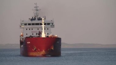 Yükü boşaltmak için bir konteynır limana giriyor, boşaltmak için bir konteynır gemisi limana giriyor. Büyük konteynır gemisi sanayi limanına giriyor, kırmızı renkli ultra büyük boş konteynır gemisi denizde, yukarıdan aşağıya bakıyor. Kargo gemisi giriyor. 