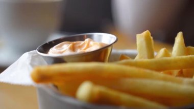 Patates kızartması beyaz sosa batırılıyor, patates kızartması beyaz sosa batırılıyor, Eller fast food kızartmalarını topluyor ve domates ketçapına batırıyor. Peynir soslu patates kızartması yakın planda, kız patates kızartması yiyor. fast food