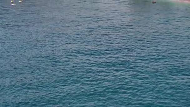 イタリアのマイオーリに多くの椅子や傘と現代のビーチの空中ビュー Amalfiの透明なターコイズブルーの地中海の水で巨大な海岸沿いのビーチでリラックスしている人々のトップドローンビュー — ストック動画