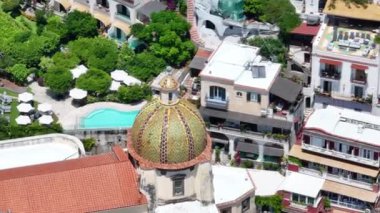 Positano, İtalya 'nın Amalfi Sahili' nde turistik bir yer. Positano 'daki yeşil sulu bitki örtüsünün içinden görünen Tyrhenian deniz kıyısındaki renkli evlerin havadan görünüşü Napoli metropolitan bölgesinde bir köydür.