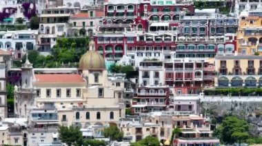 Positano, İtalya 'nın Amalfi Sahili' nde turistik bir yer. Positano 'daki yeşil sulu bitki örtüsünün içinden görünen Tyrhenian deniz kıyısındaki renkli evlerin havadan görünüşü Napoli metropolitan bölgesinde bir köydür.