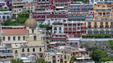 Positano, İtalya 'nın Amalfi Sahili' nde turistik bir yer. Positano 'daki yeşil sulu bitki örtüsünün içinden görünen Tyrhenian deniz kıyısındaki renkli evlerin havadan görünüşü Napoli metropolitan bölgesinde bir köydür.