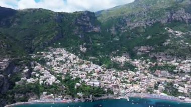 Positano, İtalya 'nın Amalfi Sahili' nde turistik bir yer. Positano 'daki yeşil sulu bitki örtüsünün içinden görünen Tyrhenian deniz kıyısındaki renkli evlerin havadan görünüşü Napoli metropolitan bölgesinde bir köydür.