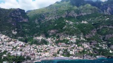 Positano, İtalya 'nın Amalfi Sahili' nde turistik bir yer. Positano 'daki yeşil sulu bitki örtüsünün içinden görünen Tyrhenian deniz kıyısındaki renkli evlerin havadan görünüşü Napoli metropolitan bölgesinde bir köydür.