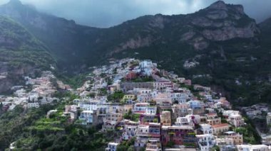 Positano, İtalya 'nın Amalfi Sahili' nde turistik bir yer. Positano 'daki yeşil sulu bitki örtüsünün içinden görünen Tyrhenian deniz kıyısındaki renkli evlerin havadan görünüşü Napoli metropolitan bölgesinde bir köydür.