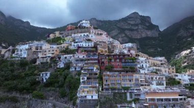 Positano, İtalya 'nın Amalfi Sahili' nde turistik bir yer. Positano 'daki yeşil sulu bitki örtüsünün içinden görünen Tyrhenian deniz kıyısındaki renkli evlerin havadan görünüşü Napoli metropolitan bölgesinde bir köydür.