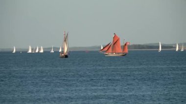 Danimarka 'da Tekne Festivali Aarhus, İskandinavya, Modern yelken yatı eski geleneksel İskandinav limanına giriyor, antik Viking gemisinin direği aşağı doğru yelken açıyor yaz yelkenli yarışları sırasında yatları kapatıyor