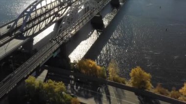 Bir köprünün insansız hava aracı videosu. Kiev 'deki modern otomobil ve eski demiryolu köprüleri. Kyiv, Ukrayna. Dnipro nehrinin üzerinde dramatik renkli gün batımı. Ukrayna 'nın tarihi manzarası. Güzel manzaralı 