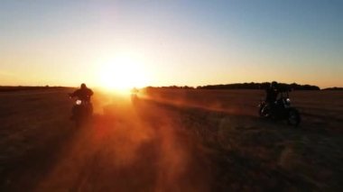 Bir grup motosikletçi sahada geziyor, insanların manzarası, gün batımına doğru motosiklet sürüyor, kır yolundan geçiyor, özgür ve mutlu, yaz tatilinin tadını çıkarıyor, arkadaşlar geçmişe dönük bisiklet sürmekten hoşlanıyor.