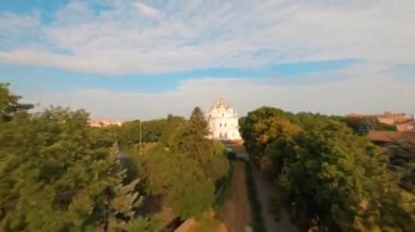 FPV, gündoğumunda kilisenin havadan görünüşü, tarihi merkez, Ukrayna. Elinde kamera olan bir dron kiliseden uçuyor. Kilisenin etrafında uç. Ukrayna 'dan Ortodoks kilisesi manzarası, 