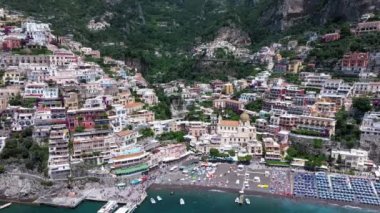 Positano, İtalya 'nın Amalfi Sahili' nde turistik bir yer. Positano 'daki yeşil sulu bitki örtüsünün içinden görünen Tyrhenian deniz kıyısındaki renkli evlerin havadan görünüşü Napoli metropolitan bölgesinde bir köydür.