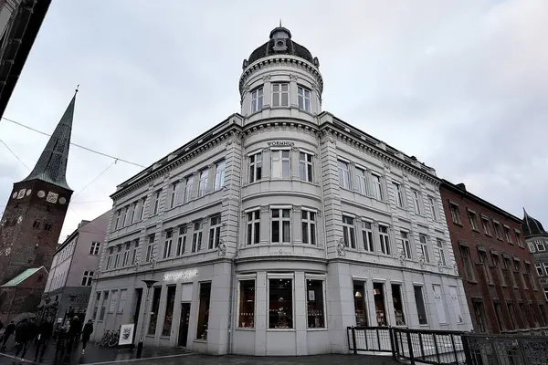 Aarhus, Danimarka, Aarhus 'ta kalabalık bir cadde ve arkasında belediye binası var. Aarhus, güneşli bir günde, şehrin mimarisi ve yayaları ile dolu bir günde Danimarka 'nın en büyük ikinci şehridir.