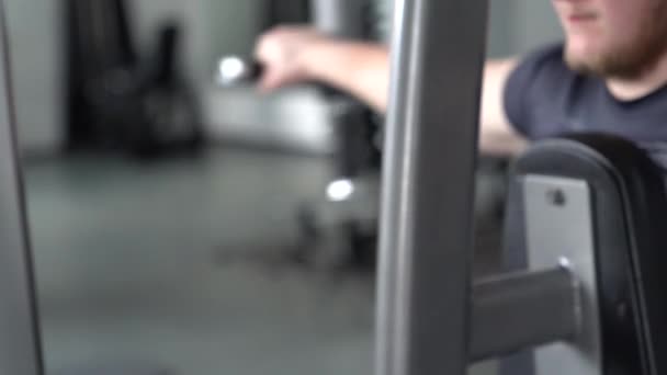 현대적인 장비와 체육관에서 체육관에서 기계에 휘트니스 보디빌더 트레이너 무거운 힘에서 — 비디오