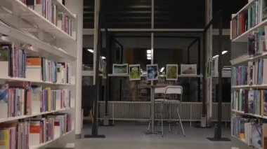 Antika Kitap satırı, klasörlerle dolu iki arşiv rafı arasında yavaş kamera hareketi. Resim, arşiv metinlerinin film ve raporlara entegrasyonu için kullanılabilir. 