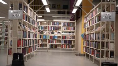 Antika Kitap satırı, klasörlerle dolu iki arşiv rafı arasında yavaş kamera hareketi. Resim, arşiv metinlerinin film ve raporlara entegrasyonu için kullanılabilir. 