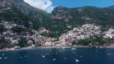 Positano, İtalya 'nın Amalfi Sahili' nde turistik bir yer. Positano 'daki yeşil sulu bitki örtüsünün içinden görünen Tyrhenian deniz kıyısındaki renkli evlerin havadan görünüşü Napoli metropolitan bölgesinde bir köydür.