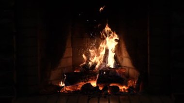 Şömine. Rahatlatıcı Şömine. Yakacak odun. Bir kır evinin alevleri. Sıcaklık ve ev konforu. Toprak. Şöminede ateş yanıyor. Şöminede güzel bir ateş, yanan bir odun. 