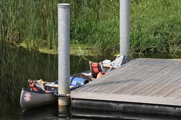 İskeleye park etmiş tekneyle göl manzarasını kapatın. Yerel limanda park edilmiş tekneler.