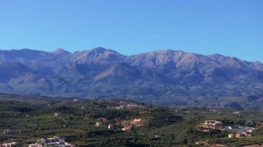 Yunanistan 'daki Girit adasının Dağ Havası manzarası. Gün batımında dağ manzarası, zeytin ağaçları ve üzüm bağları. Güney Ege Denizi üzerinde uçan hava videosu Oia, Santorini, Yunanistan, gün doğumunu gösteriyor