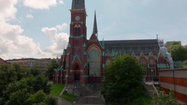 Fassbergs Kyrka, Göteborg, İsveç 'in hava manzarası, şehir merkezinin havadan görünüşü, parkın olduğu şehir kanalı manzarası, önü ağaçlar, eski bina, İskandinav şehri kıyı şeridi, çevre binalar. 