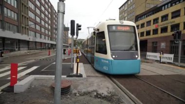 Göteborg, İsveç - 23 Mart 2023: Güneşli bir günde yürüyen yayalarla İsveç 'in Göteborg kentindeki tramvayda hareket eden tramvay. Merkez İstasyon Meydanı, Göteborg. Tramvaylar geçiyor, Tramvay yolda.