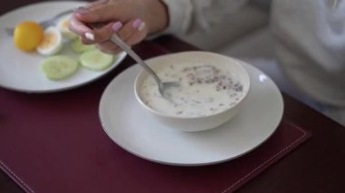 Buckwheat porridge, Pouring milk into the bowl with wheat buckwheat bran cereal. Healthy breakfast concept, Breakfast. Buckwheat Porridge with Milk in White Bowls and Pastries nearby. Top View