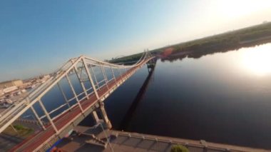 FPV, Kyiv şehrindeki yaya köprüsü. Dnipro nehri üzerinde köprü, altın saat, insansız hava aracı görüntüsü Kyiv yaya köprüsü, Truchaniv adası ve Dinyeper nehri güzel güneşli bir günde. Ukrayna 'nın başkenti