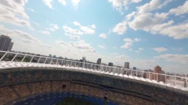 FPV uçuşu, Stadyum. Gece gündüz şehir manzarası. Yukarıdan aydınlık stadyuma kadar oyunlar ve taraftarlarla dolu bir manzara. Kiev, Ukrayna, Olimpiyat Stadyumu.