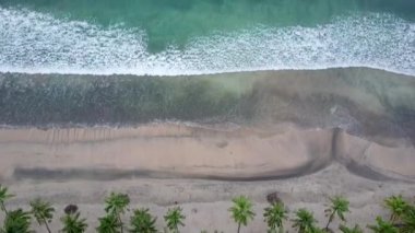 Sahildeki dalgaların çarpışma fotoğrafı. Tropik plaj sörfü. Soyut okyanus manzarası, Komodo Ulusal Parkı 'ndaki ünlü pembe plajda yatan bir çift. Turkuaz nane rengi berrak su, 