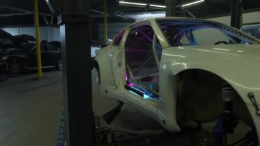 Akort araba. Motor garajda. Sürüklenen araba. Araba servisi. Yakından, Benzin istasyonunda araba tamiri. Benzin istasyonunda avttomobile motor bloğu, fren yastıkları, araba cilalama, otomobil 