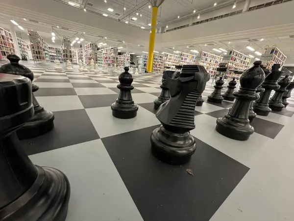 Empty park with big chess figures and empty chairs on background.Nobody playing in games.