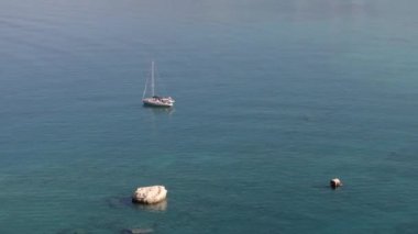 Güzel bir yatın havadan görünüşü. Yazın gün batımında denizde tekne gezisi. Ada, Yunanistan. Lüks yatlar, yelkenliler, temiz mavi sular, gökyüzü, dağ manzarası. Seyahat et. Seyahat tatili, mavi deniz lagünü. 