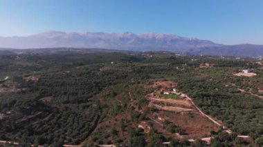 Yunanistan 'daki Girit adasının Dağ Havası manzarası. Gün batımında dağ manzarası, zeytin ağaçları ve üzüm bağları. Güney Ege Denizi üzerinde uçan hava videosu Oia, Santorini, Yunanistan, gün doğumunu gösteriyor