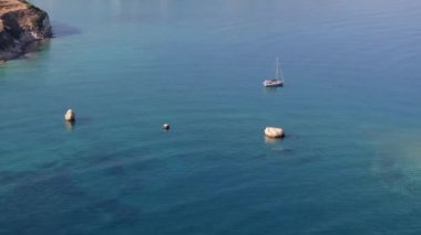 Güzel bir yatın havadan görünüşü. Yazın gün batımında denizde tekne gezisi. Ada, Yunanistan. Lüks yatlar, yelkenliler, temiz mavi sular, gökyüzü, dağ manzarası. Seyahat et. Seyahat tatili, mavi deniz lagünü. 