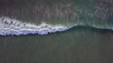Sahildeki dalgaların çarpışma fotoğrafı. Tropik plaj sörfü. Soyut okyanus manzarası, Komodo Ulusal Parkı 'ndaki ünlü pembe plajda yatan bir çift. Turkuaz nane rengi berrak su, 