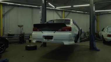 Akort araba. Motor garajda. Sürüklenen araba. Araba servisi. Yakından, Benzin istasyonunda araba tamiri. Benzin istasyonunda avttomobile motor bloğu, fren yastıkları, araba cilalama, otomobil 