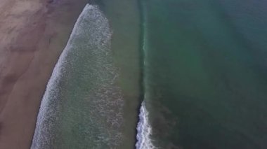Sahildeki dalgaların çarpışma fotoğrafı. Tropik plaj sörfü. Soyut okyanus manzarası, Komodo Ulusal Parkı 'ndaki ünlü pembe plajda yatan bir çift. Turkuaz nane rengi berrak su, 