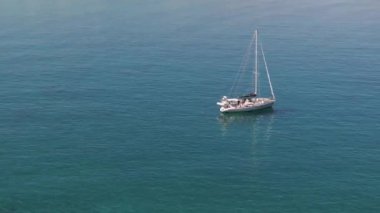 Güzel bir yatın havadan görünüşü. Yazın gün batımında denizde tekne gezisi. Ada, Yunanistan. Lüks yatlar, yelkenliler, temiz mavi sular, gökyüzü, dağ manzarası. Seyahat et. Seyahat tatili, mavi deniz lagünü. 