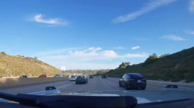 Los Angeles, California USA - 08 18 2023: Kaliforniya 'da şehirlerarası otoyolda araba sürmek. Arabanın ön camından dışarı odaklanmış görüntü. Bulanık banliyö yolu. Otomatik kameranın içinde 