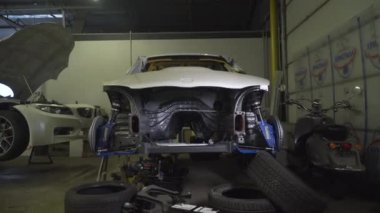 Akort araba. Motor garajda. Sürüklenen araba. Araba servisi. Yakından, Benzin istasyonunda araba tamiri. Benzin istasyonunda avttomobile motor bloğu, fren yastıkları, araba cilalama, otomobil 