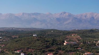 Yunanistan 'daki Girit adasının Dağ Havası manzarası. Gün batımında dağ manzarası, zeytin ağaçları ve üzüm bağları. Güney Ege Denizi üzerinde uçan hava videosu Oia, Santorini, Yunanistan, gün doğumunu gösteriyor