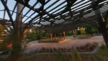Kyiv şehrindeki Sonsuz Zafer Parkı. Hava güzel, FPV insansız hava aracı yolda uçuyor, Kiev, Ukrayna, Park Köprüsü Mariinsky Parkı Kiev Ukrayna 'nın yeşil çim tepesi 