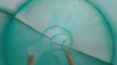 Su Kaydırağı, Genç Çocuk Su Parkı 'nda kapalı bir kaydırağın içinde iyi eğlenceler. Suyun üstünde eğlence. Su kaydırağı sürüşünün tadını çıkarıyorum. Sürücü taktiği. Su parkındaki su kaydırağına bakış açısı, kamerayla su parkında eğlenmek.